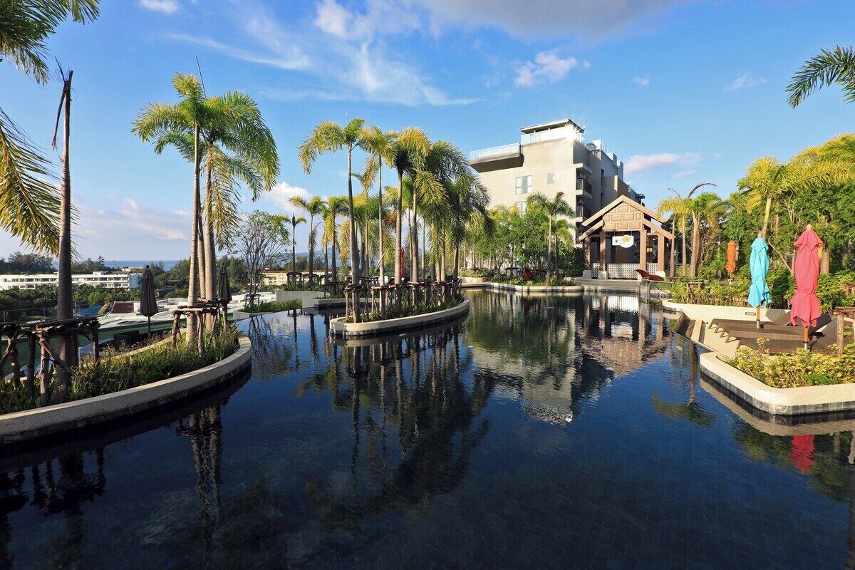Ein Hotel mit Pool, Palmen und einem Gebäude mit flachem Dach.