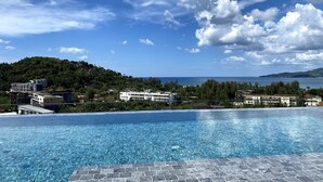 Ein Pool mit Blick auf eine Hügelkette und Gebäude im Hintergrund.