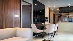 Ein modernes Interieur mit einer Couch, einem Esstisch, Stühlen und einer Küchenzeile.
