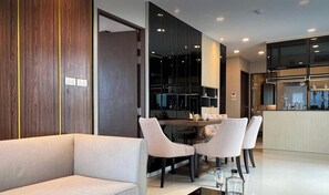 Ein modernes Interieur mit einer Couch, einem Esstisch, Stühlen und einer Küchenzeile.