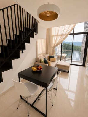 Ein modernes Interieur mit Treppe, Esstisch, Stühlen und Seeblick.