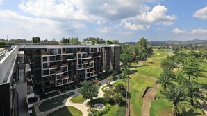 Moderni, useita kerroksia käsittävä rakennus, jossa on sisäpiha, golfkenttä ja taustalla järvi.