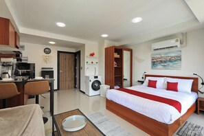 Ein modernes Hotelzimmer mit Bett, Schreibtisch, Waschmaschine und Essbereich.