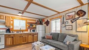 Una cocina funcional con armarios de madera, un refrigerador y una zona de comedor.