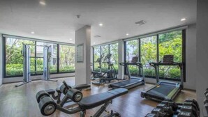 Une salle de sport équipée de tapis de course, d’haltères et d’appareils de musculation.