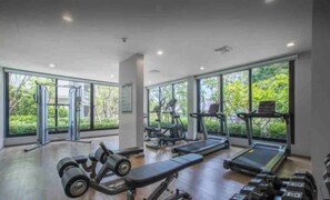 Ein Fitnessstudio mit Laufbändern, Kurzhanteln und Krafttrainingsgeräten.