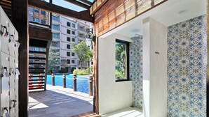 Une chambre d’hôtel avec vue sur une piscine, un plafond en bois et des carreaux décorés.