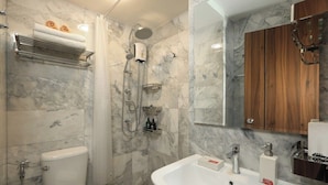 Ein Badezimmer mit Marmorwand, einer Dusche, einer Toilette und einem Waschbecken mit Spiegel.