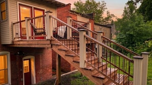 Ein zweistöckiges Haus mit einer Holztreppe und einem Balkon.