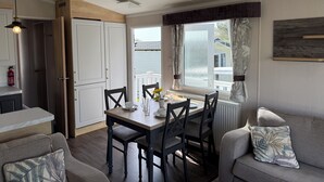 Un espacio habitable compacto con comedor, kitchenette y sofá.