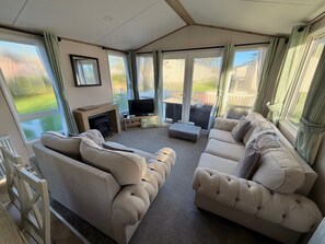 Living area - All the home comforts of a Classic Holiday Home, plus a larger decking. Two bedroom holiday home sleeping 4 people; 1 double & 1 twin room. Lounge, dining table and chairs, fully equipped kitchen, shower room. (West Lulworth)