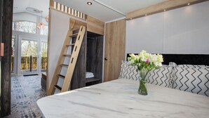 A modern interior with a marble table, a wooden ladder, and a view of the outdoors.