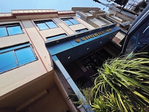 A building with a sign reading 'SHOBHA INN' and multiple windows. - Hotel Shobha Inn (Lucknow)