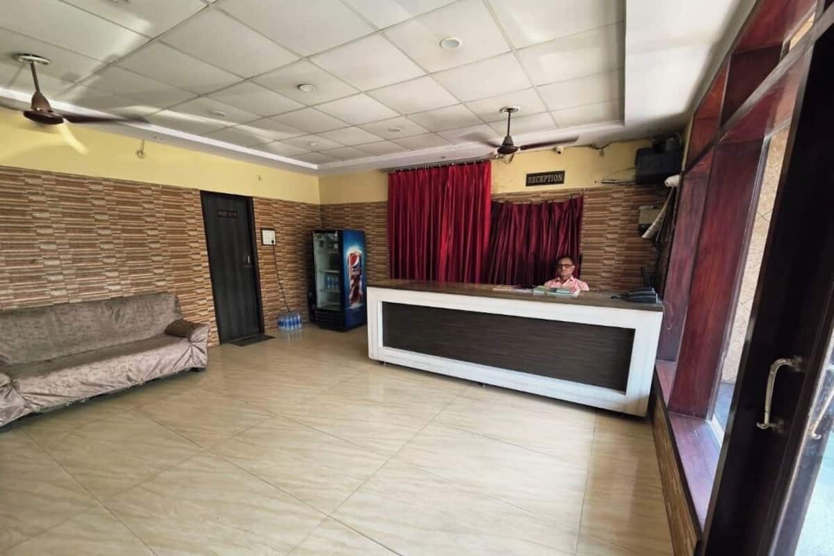 A reception area with a reception desk, a sofa, a TV, and a ceiling fan.