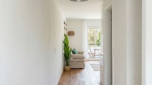 Ein Gang mit Holzboden, einer weißen Wand und einer Deckenleuchte.