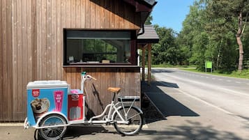 Un edificio de madera con un remolque para bicicleta adosado.