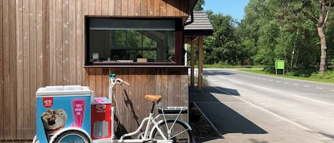 Un bâtiment en bois auquel est attachée une remorque à vélo sur le côté.