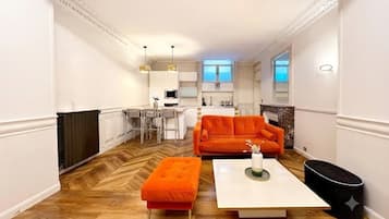 Una sala de estar moderna con sofá, reposapiés y mesa de centro.