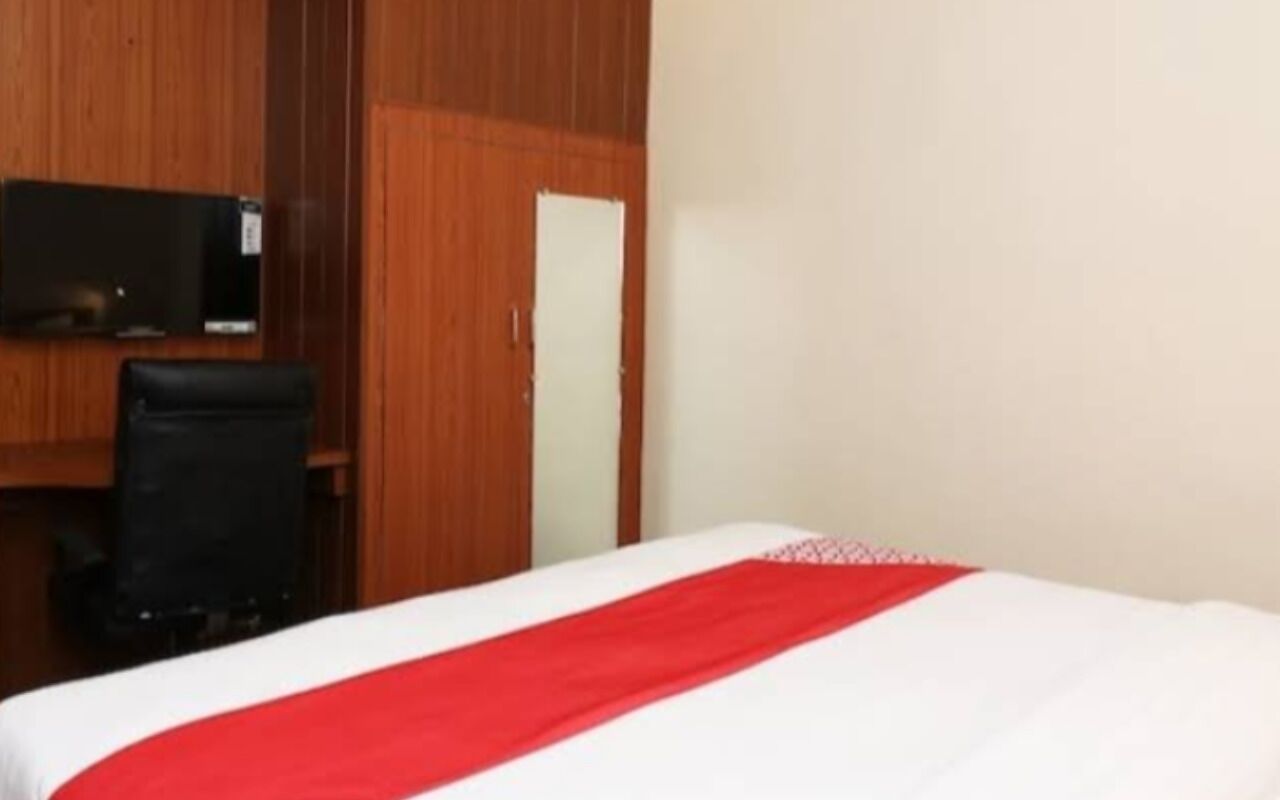Une chambre d’hôtel équipée d’un lit, d’un bureau, d’une chaise et d’un téléviseur.