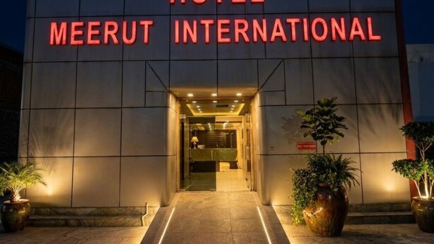 Exterior del Hotel Meerut International, con fachada moderna y una entrada bien iluminada.
