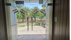 Una entrada con un letrero de SALIDA, un letrero con la letra G y tres banderas de India.