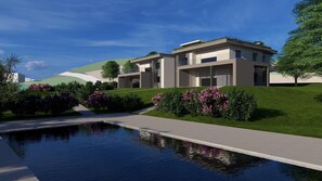 A modern residential building with a swimming pool, surrounded by well-maintained gardens and a clear sky. - Villa Aqua_Lydia Suite Apartment_Lake View & Pool (San Felice del Benaco)