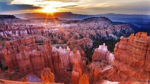 Paisaje de cañón con formaciones rocosas destacadas y un atardecer.