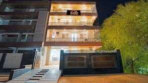 A multi-story hotel with a signboard, balconies, and a gated entrance. - SnapStayz (Noida)