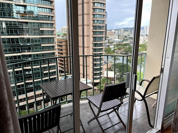Un balcon offrant une vue sur les gratte-ciel et le paysage urbain.