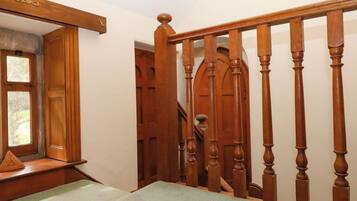 A wooden staircase with a handrail, a door with a window, and a carpeted landing.