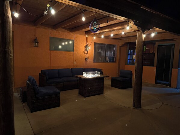 An outdoor seating area with a sectional sofa, two chairs, a table, and a hanging light fixture. - Desert Sunset Escape-Private, Peaceful & Relaxing (El Paso)