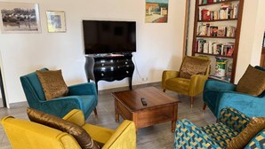 A living room with two sofas, a coffee table, a TV, and a bookshelf. - Traveling in the 21st century is all about comfort (Mouriès)