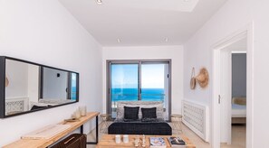 A bedroom with a large window, a bed, a desk, and a mirror. - Borderline (Metline)