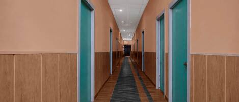 A long hallway with doors on both sides, leading to individual rooms.
