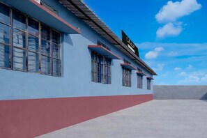 A building with a flat roof, multiple windows, and a clear sky. - Deluxe Jalukbari Bus Stand Velvet Stay (Guwahati)