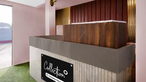 A reception desk with a sign reading 'Collection Company-Service.' - Deluxe Jalukbari Bus Stand Velvet Stay (Guwahati)