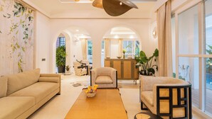 A modern living room with a sofa, armchair, and a coffee table. - ELIVAAS Purple Coral Luxe 5-BHK Villa (Assagao)