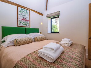 A room with a bed, pillows, a window with a view, and a poster on the wall. - The Barn (Malvern)