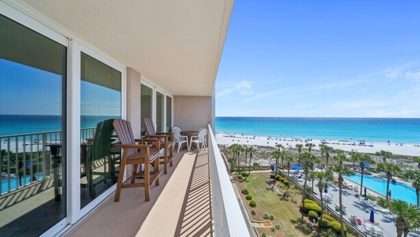 Een balkon met uitzicht op het strand en een zwembad.