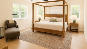 Una camera da letto con un letto a baldacchino, una sedia, due comodini e una ventola a soffitto.