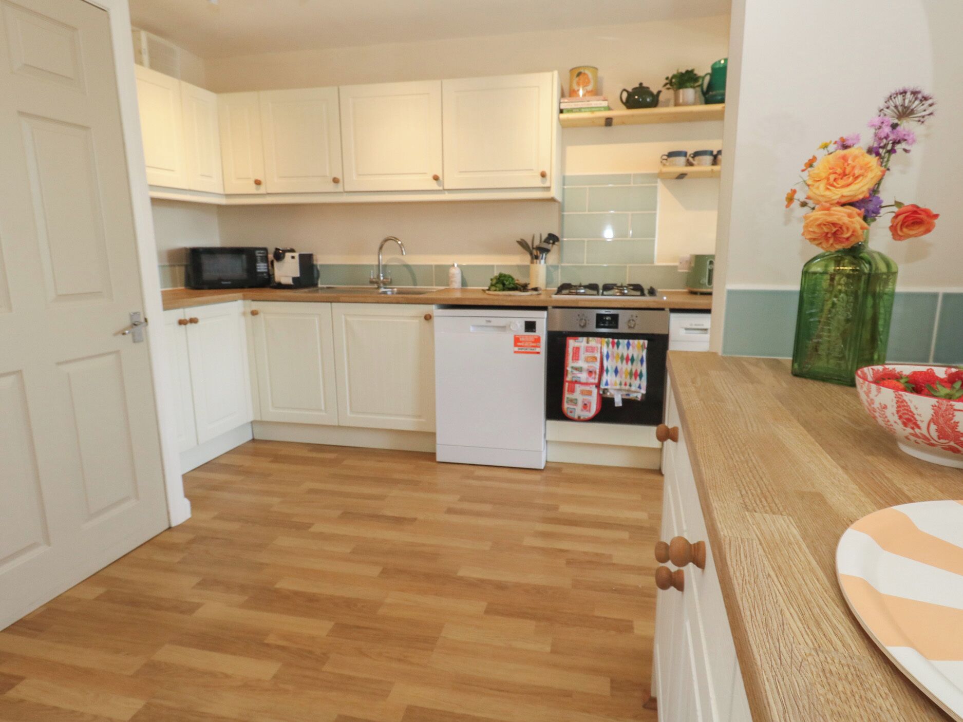 A kitchen with white cabinets, a microwave, a dishwasher, and a stove.