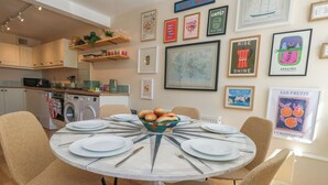 A dining area with a round table, chairs, and a bowl of bread. - Mallow Cottage (Swanage)