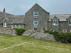A stone building with multiple windows and a sloped roof. - Mallow Cottage (Swanage)