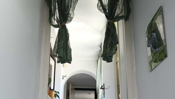 A hallway with a wooden floor, white walls, and a door at the end. - FeWoSchwarz small apartment in Bühlertal (Bühlertal)