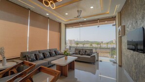 A modern living room with a sofa set, coffee table, and wooden chairs. - Panna Palace-A Luxury Boutique Hotel (Amer)