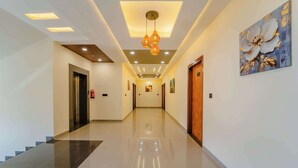 A hotel hallway with a polished floor, recessed lighting, and a large floral painting on the wall. - Panna Palace-A Luxury Boutique Hotel (Amer)