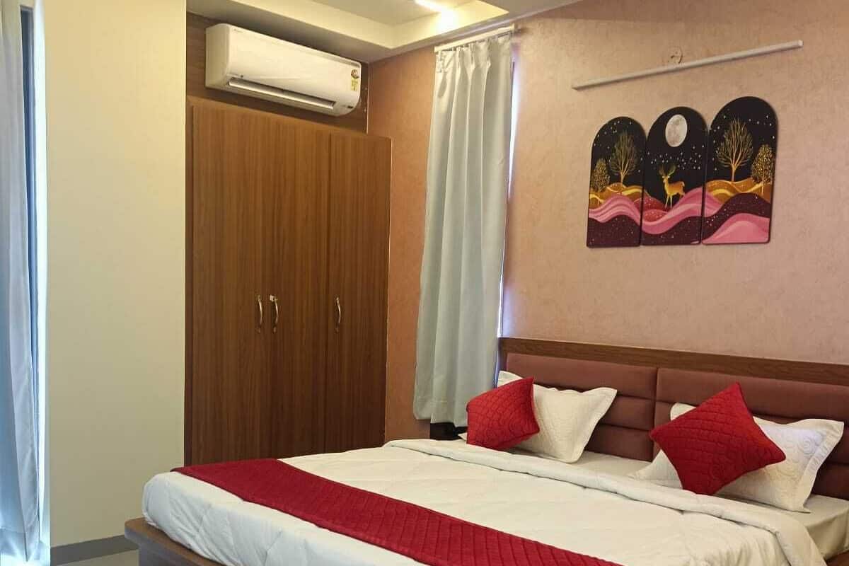 Ein Schlafzimmer mit Bett, Deckenventilator, Klimaanlage, Holzschrank und Wandbild.