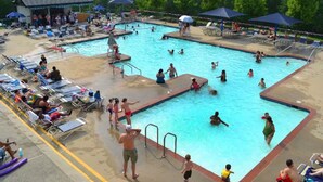 Une piscine avec plusieurs couloirs de nage, des chaises longues et des parasols.