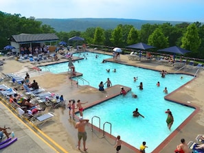 A swimming pool with multiple lanes, sun loungers, and umbrellas.