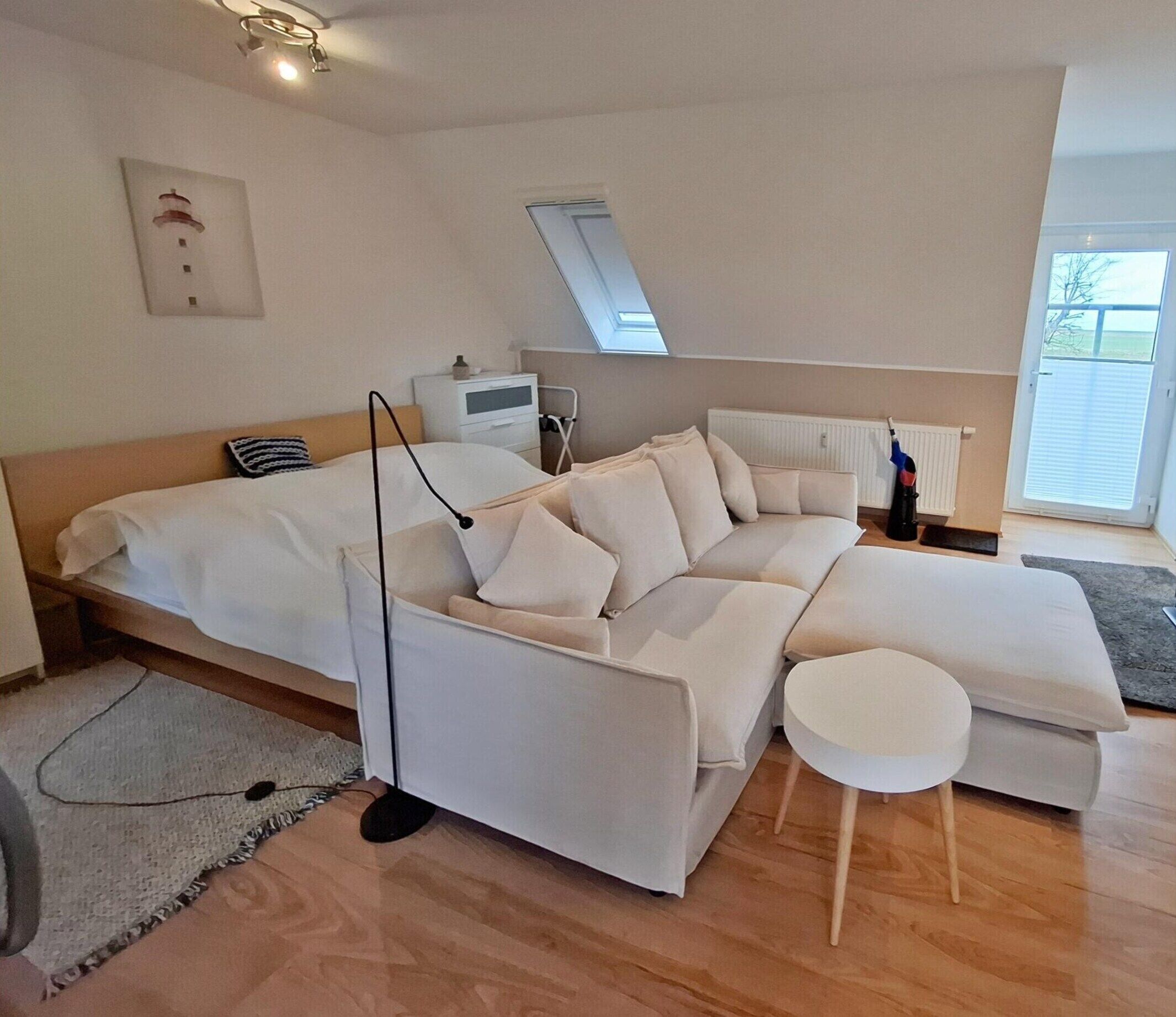 Uma sala de estar moderna com um sofá, uma mesa pequena e um radiador.